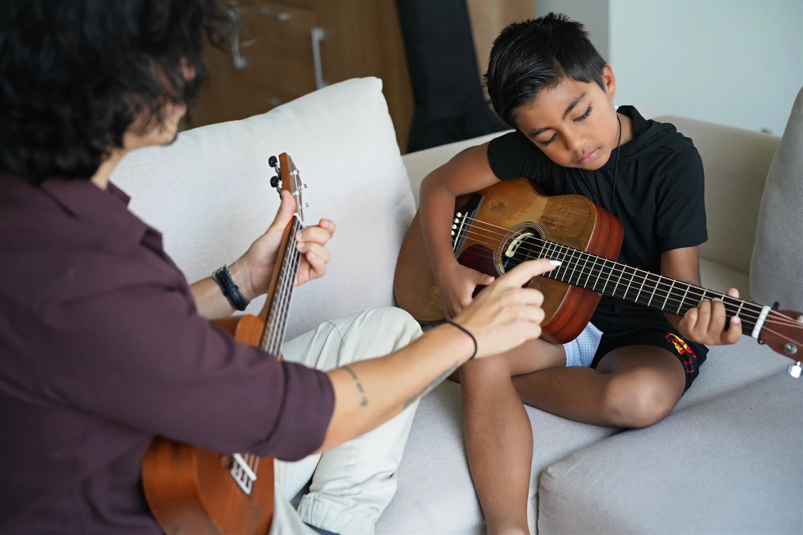 A child learning guitar with Giancarlo